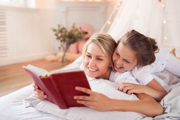 Escena familiar. Feliz madre e hija en una cama