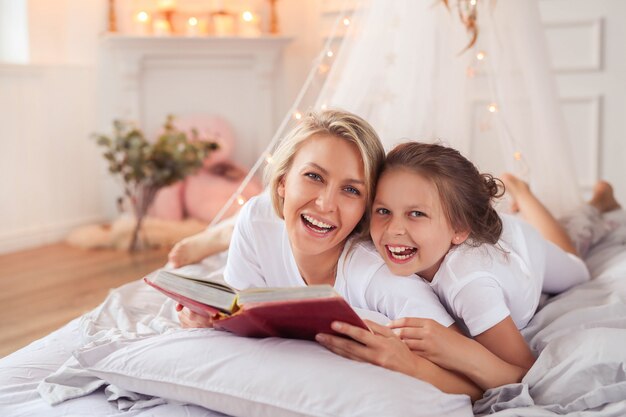 Escena familiar. Feliz madre e hija en una cama