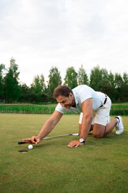 Escena con hombre en el campo de golf.