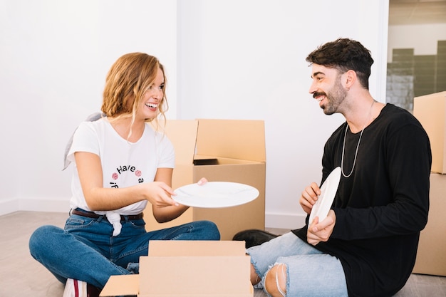 Escena de mudanza con pareja sujetando plato