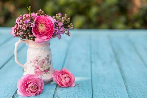 Escena de primavera con jarrón y flores en tonos rosas