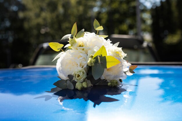 Escena de recién casados con flores en el coche.