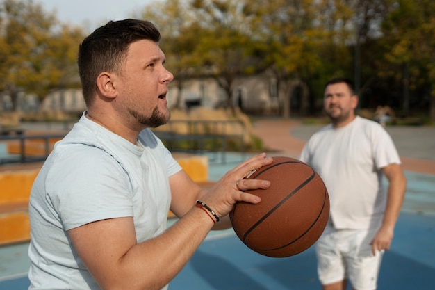 Foto gratuita escenas auténticas de hombres de talla grande jugando al baloncesto