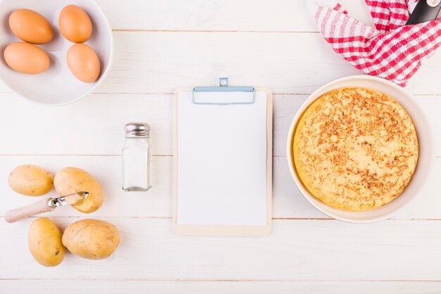 Escritorio de cocina con portapapeles y pastel