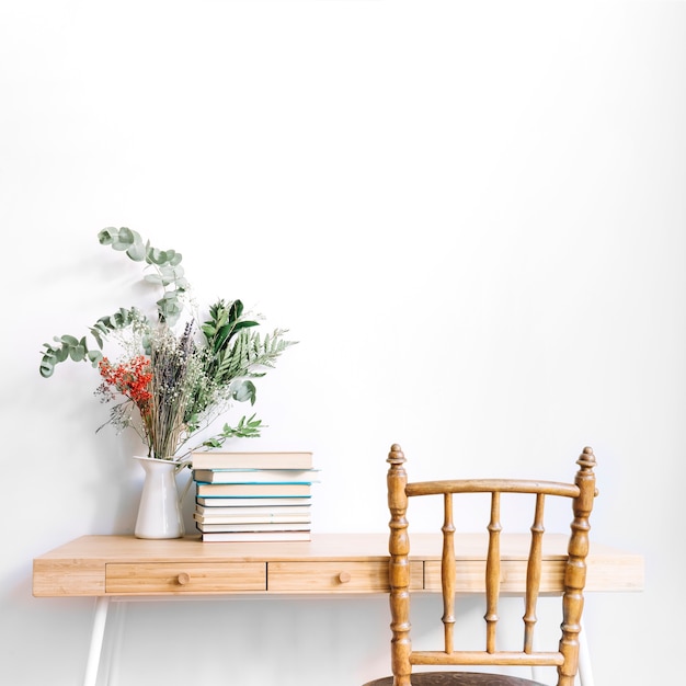 Escritorio decorativo con libros al lado de planta