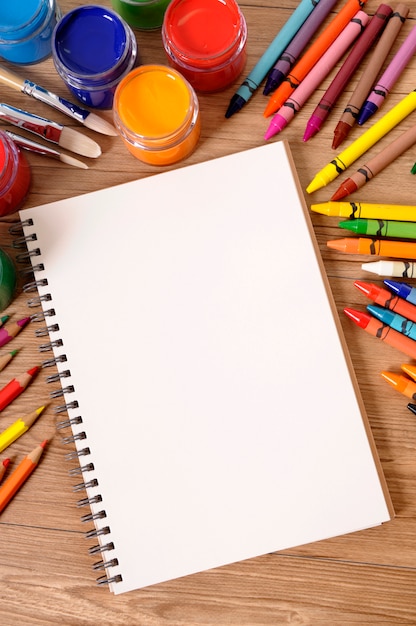 Foto gratuita escritorio de escuela con bloc de notas y lápices de colores