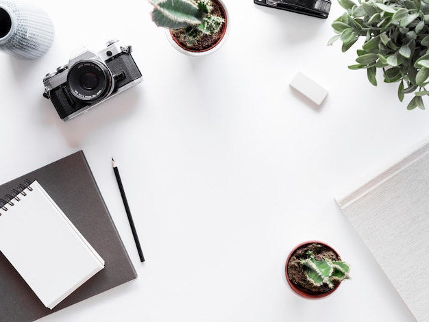 Escritorio con libreta y cámara de fotografías