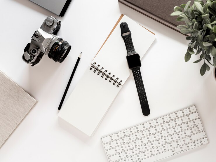 Foto gratuito escritorio con libreta y reloj