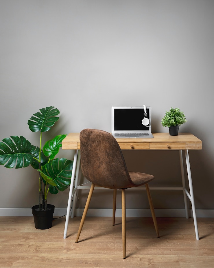 Foto gratuito escritorio de madera con silla y portátil gris