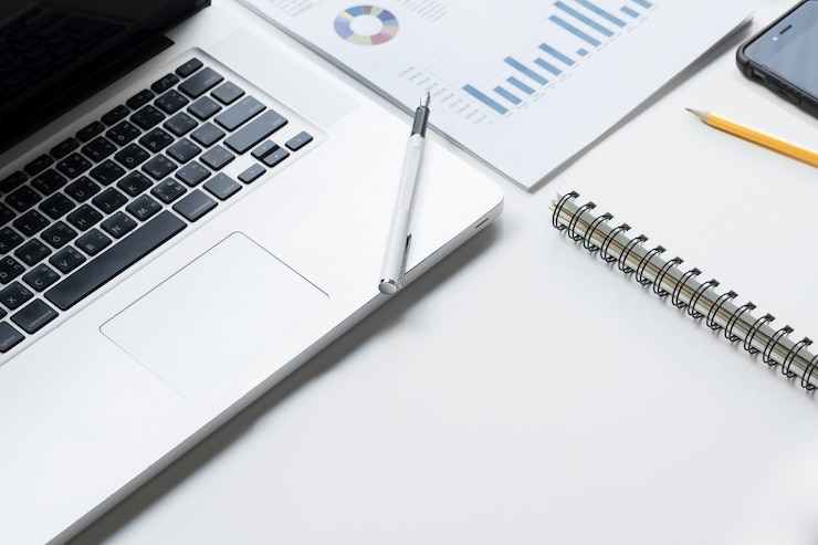 Foto gratuito escritorio de negocios con un teclado, gráfico de gráfico de informe, lápiz y tableta en tabla blanca