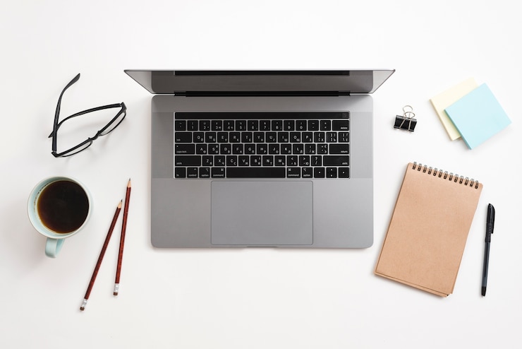 Foto gratuito escritorio de oficina con ordenador portátil y una libreta