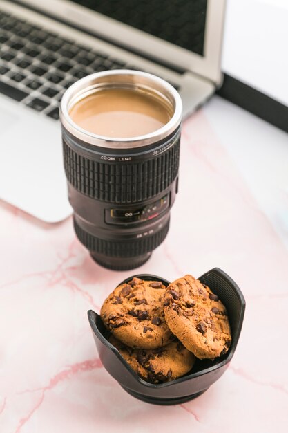 Escritorio de oficina con una taza de café y galletas