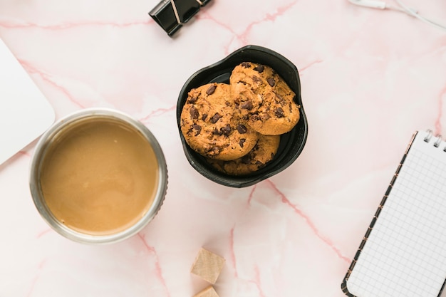 Escritorio de oficina con una taza de café y galletas