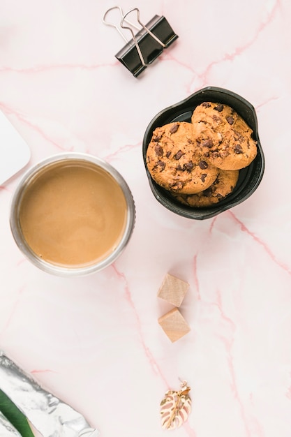 Escritorio de oficina con una taza de café y galletas