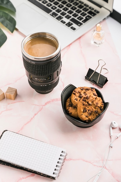 Escritorio de oficina con una taza de café y galletas