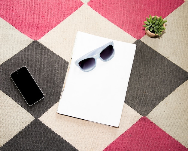 Escritorio de oficina con teléfono móvil y unas gafas