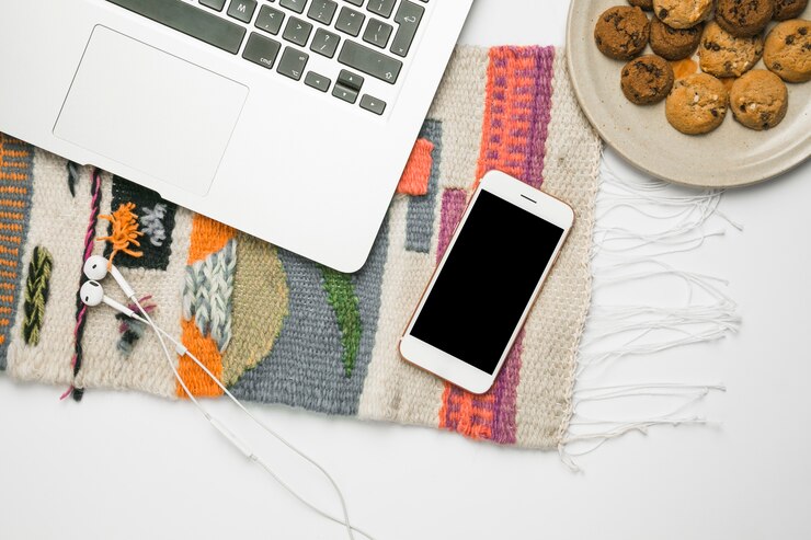Foto gratuito escritorio de oficina con teléfono móvil y galletas