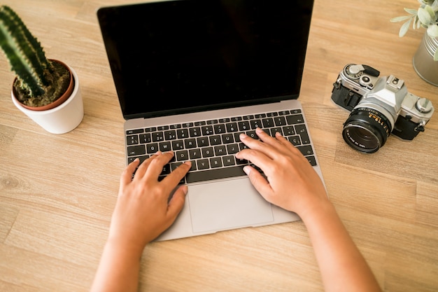 Escritorio con ordenador portátil y cámara de fotos