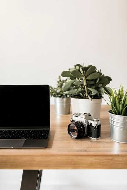 Escritorio con ordenador portátil y cámara de fotos