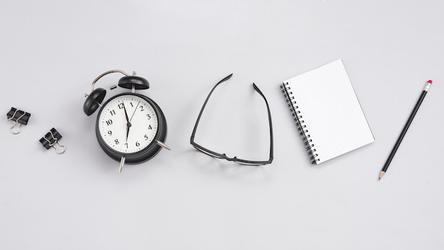 Foto gratuita escritorio con un reloj y elementos de oficina