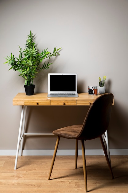 Escritorio simple de madera con silla y laptop