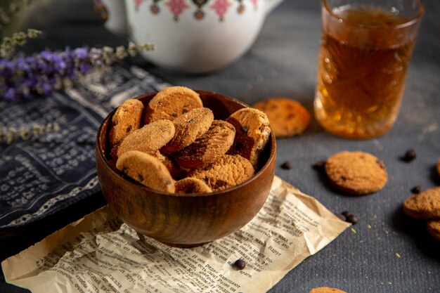 Un escritorio de vista frontal con tetera y galletas de superficie gris galleta de té de galletas dulces