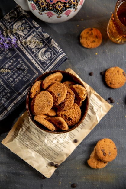 Un escritorio de vista superior con tetera y galletas dentro de la placa