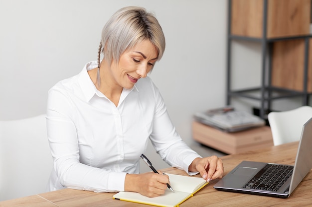 Foto gratuita escritura femenina de alto ángulo en agenda