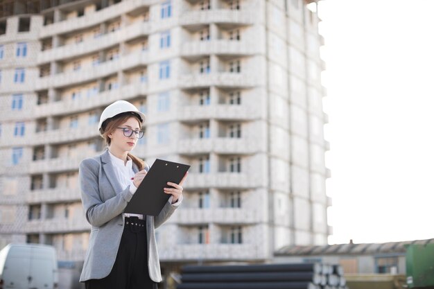 Escritura femenina del arquitecto en el tablero en el sitio