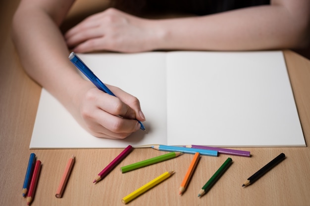 Foto gratuita escritura de la mano de la mujer en el libro en blanco