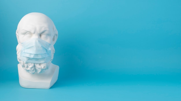 Foto gratuita escultura de mármol de figura histórica con máscara médica