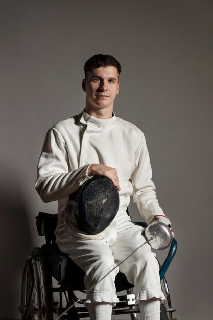 Esgrimista discapacitado en equipo especial sentado en una silla de ruedas