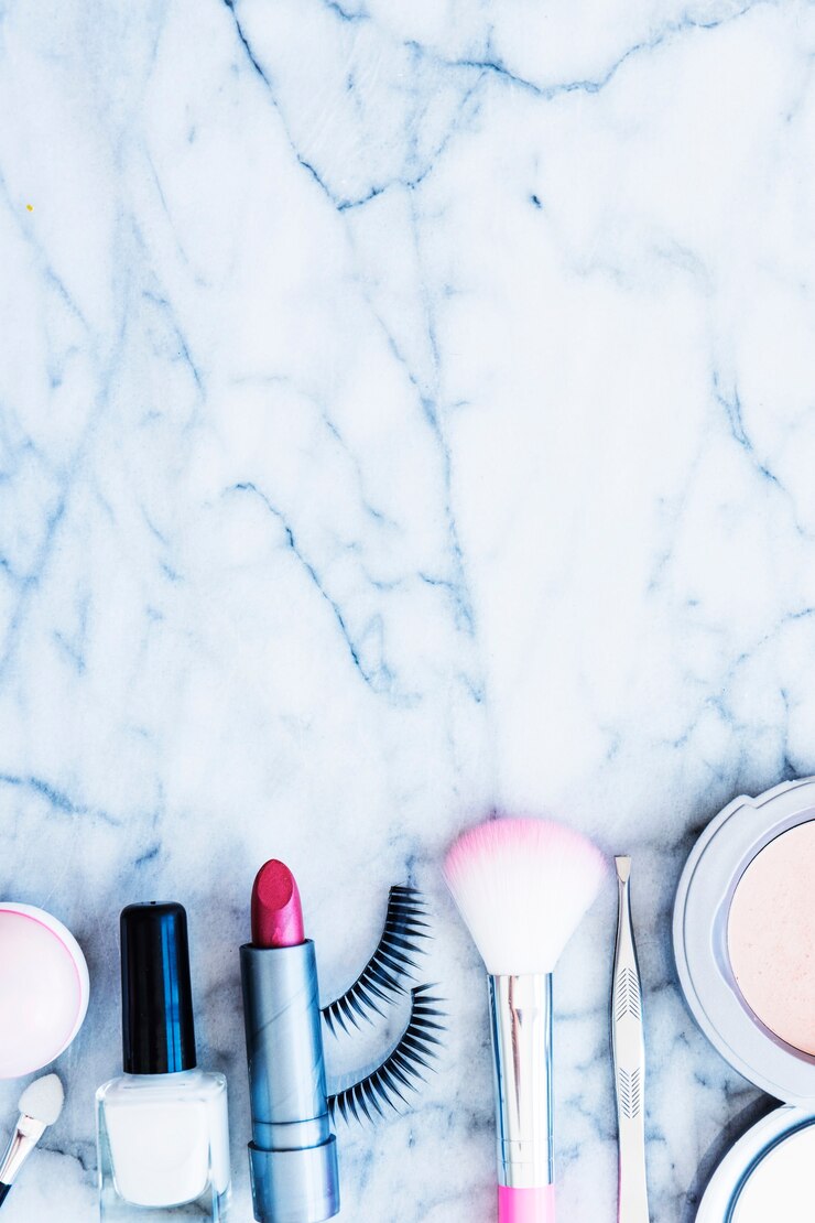 Foto gratuito esmalte de uñas; rubores lápiz labial; pinzas; polvo compacto y pestañas dispuestas sobre fondo texturado mármol
