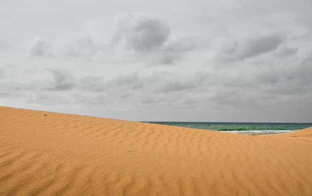 Espacio libre de fondo de arena para su decoración Mar borroso con cielo en las nubes Clima nublado en verano