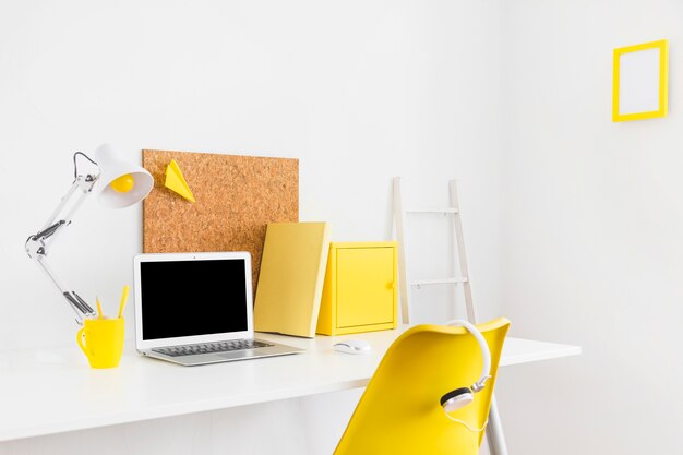 Espacio de trabajo brillante creativo con detalles amarillos y tablero de corcho