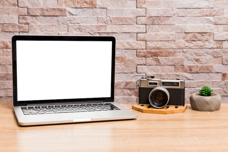 Foto gratuito espacio de trabajo creativo con laptop y cámara retro.