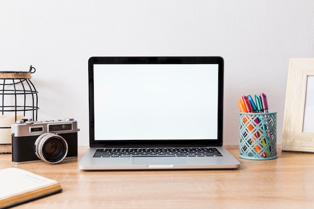 Foto gratuita espacio de trabajo con laptop y cámara en disposición.