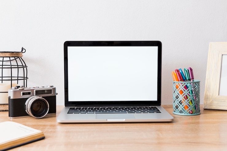 Foto gratuito espacio de trabajo con laptop y cámara en disposición.