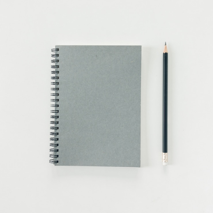 Foto gratuito espacio de trabajo mínimo - foto plana estable creativa de escritorio de espacio de trabajo con cuaderno de dibujo y lápiz de madera sobre fondo blanco de espacio de copia. vista superior, fotografía plana.