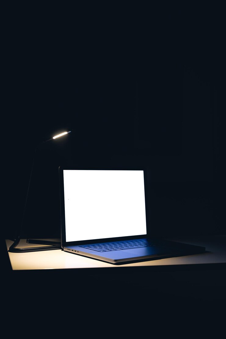 Foto gratuito espacio de trabajo de pantalla en blanco con computadora portátil en la mesa por la noche espacio de copia