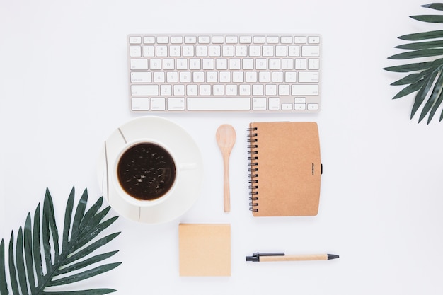 Espacio de trabajo con taza de teclado y estacionario