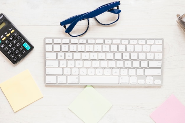 Espacio de trabajo con teclado de computadora y gafas