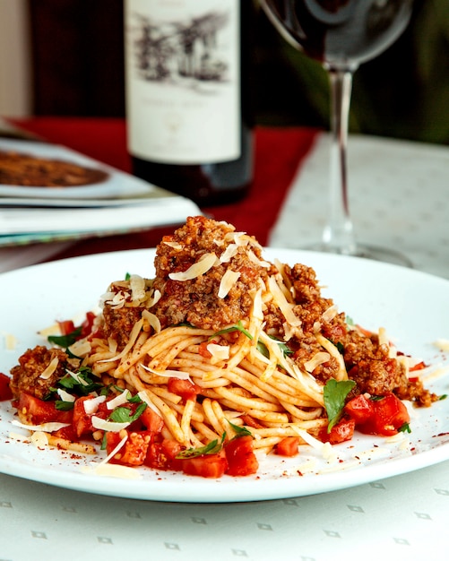 Espaguetis con carne picada cubitos de tomate queso y menta