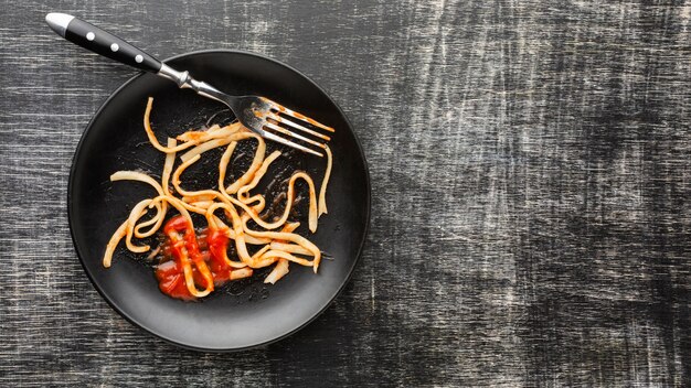 Espaguetis de desperdicio de comida sobrante en placa