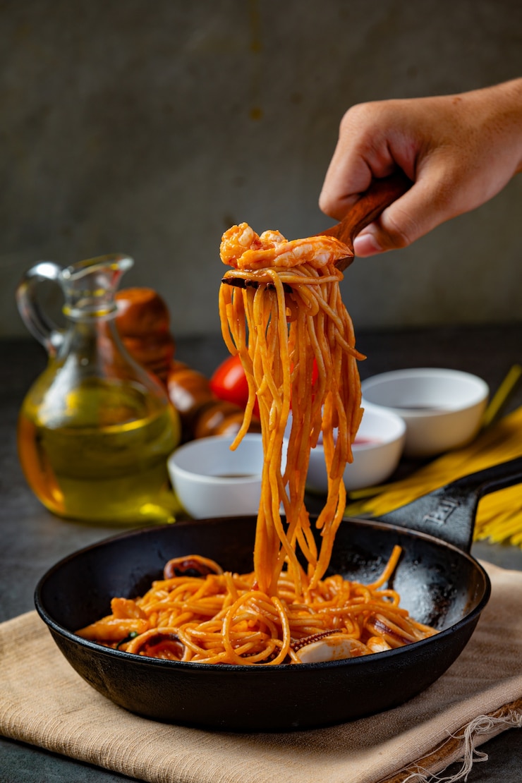 Foto gratuito espaguetis de mariscos con salsa de tomate decorados con hermosos ingredientes.