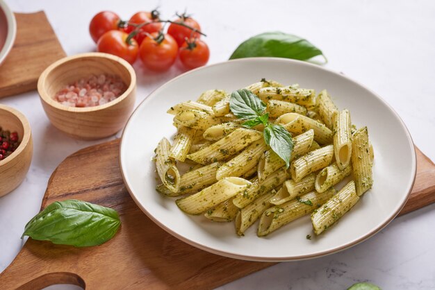 Espaguetis de pasta con calabacín, albahaca, crema y queso sobre mesa de piedra.