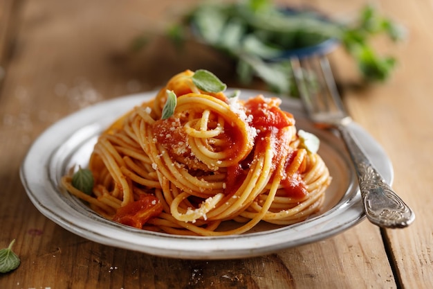 Espaguetis de pasta con salsa de tomate y queso servidos en un plato