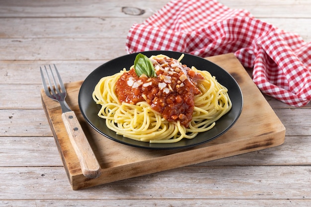 Espaguetis con salsa boloñesa en mesa de madera