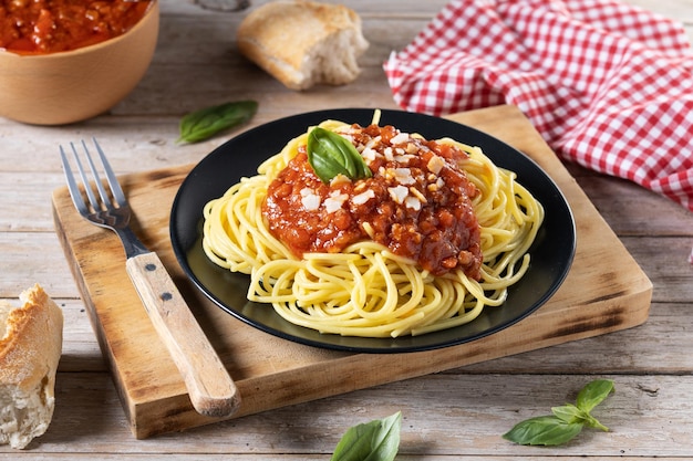 Espaguetis con salsa boloñesa en tablexA de madera