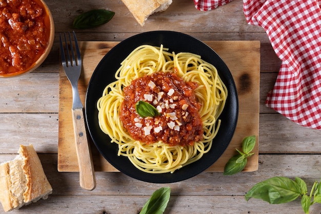 Espaguetis con salsa boloñesa en tablexA de madera